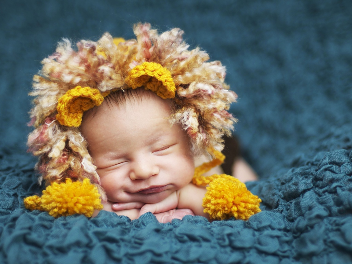 Милый спящий младенец в забавной шапке львенка