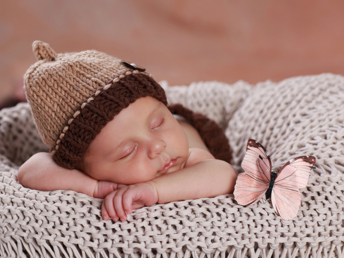 Cute sleeping baby in a brown knitted hat