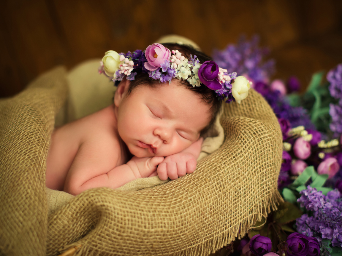 Милый спящий младенец с венком на голове