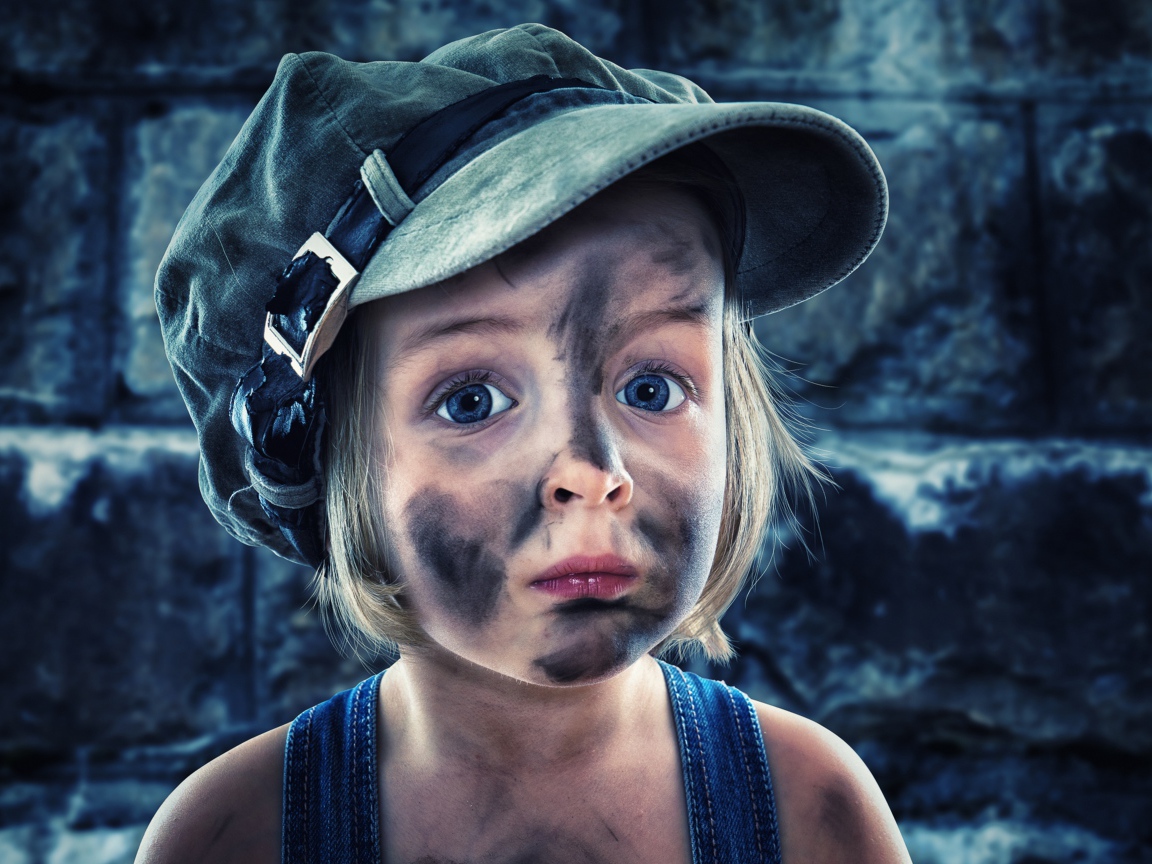 Смешная девочка в кепке с грязным лицом