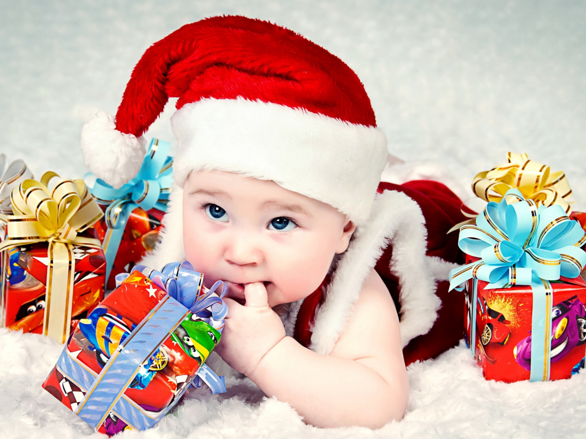 Маленький ребенок в новогоднем костюме с подарками