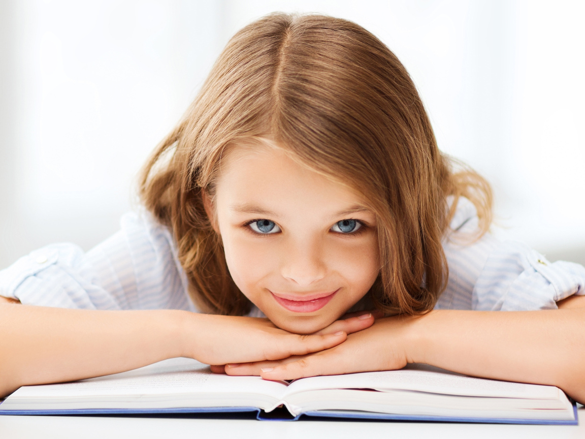 Маленькая голубоглазая девочка школьница с книгой 