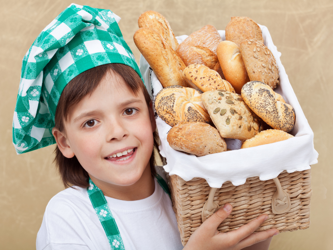 Маленькой поваренок с корзиной свежей выпечки 