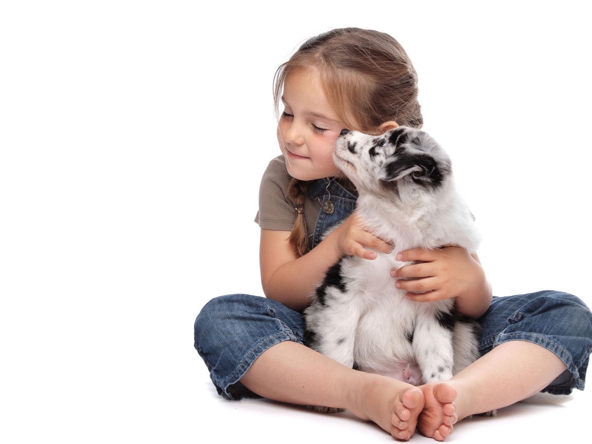 Маленькая девочка обнимает щенка на белом фоне