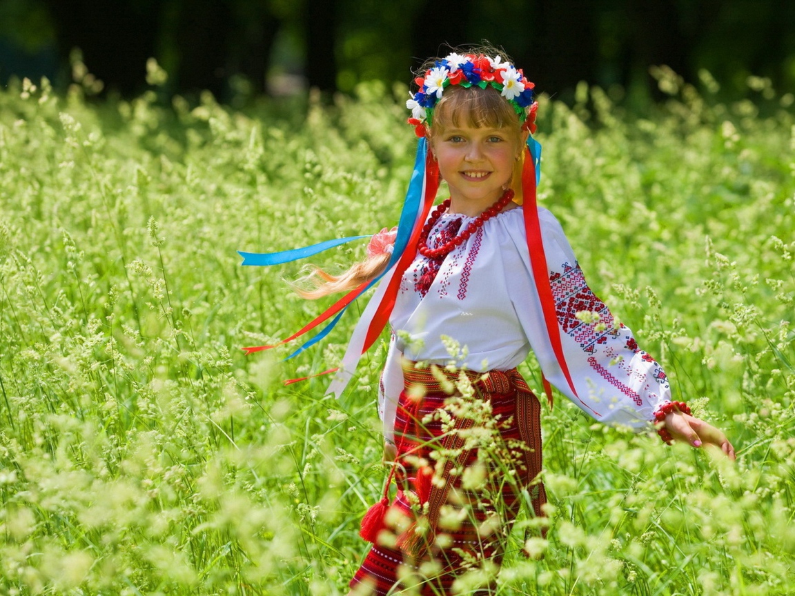 Маленькая девочка в костюме с венком на голове