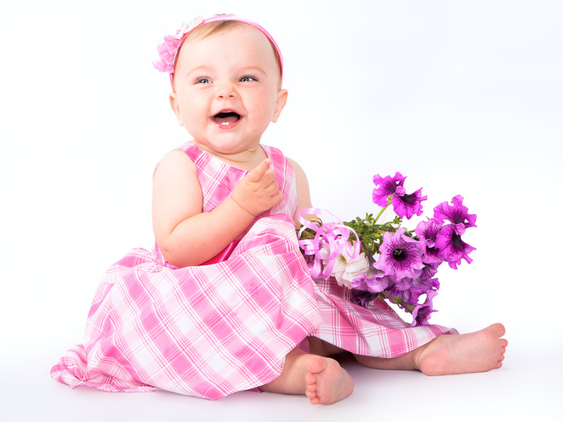Маленькая улыбающаяся девочка с букетом петунии на белом фоне