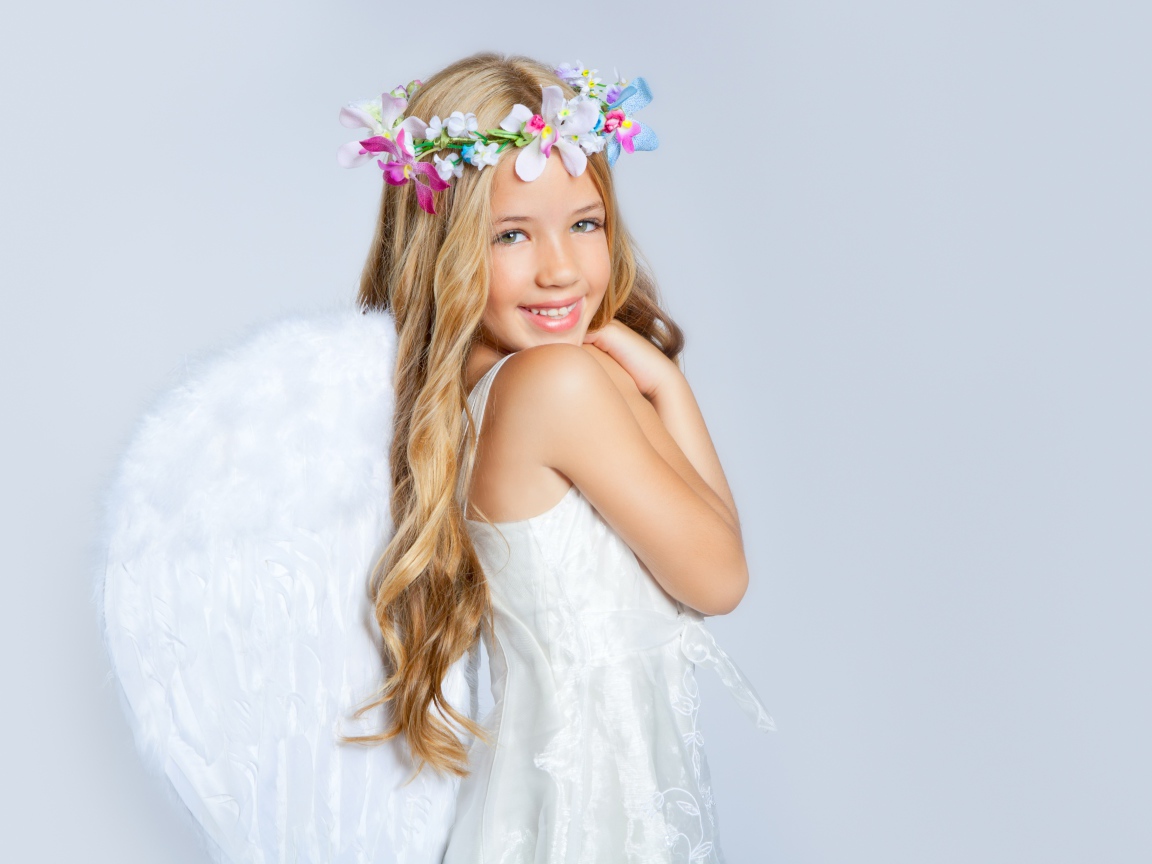 Улыбающаяся милая девочка в костюме ангела