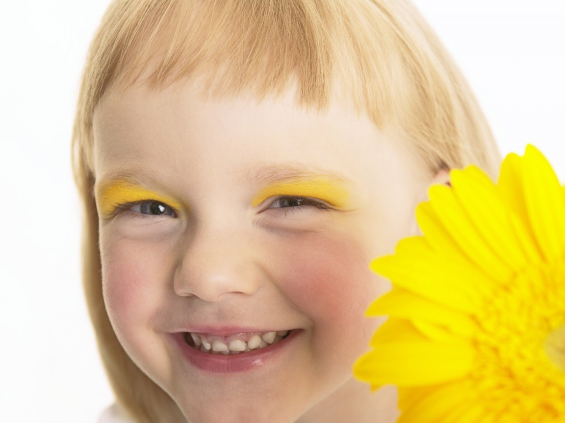 Улыбающаяся девочка с желтым цветком герберы