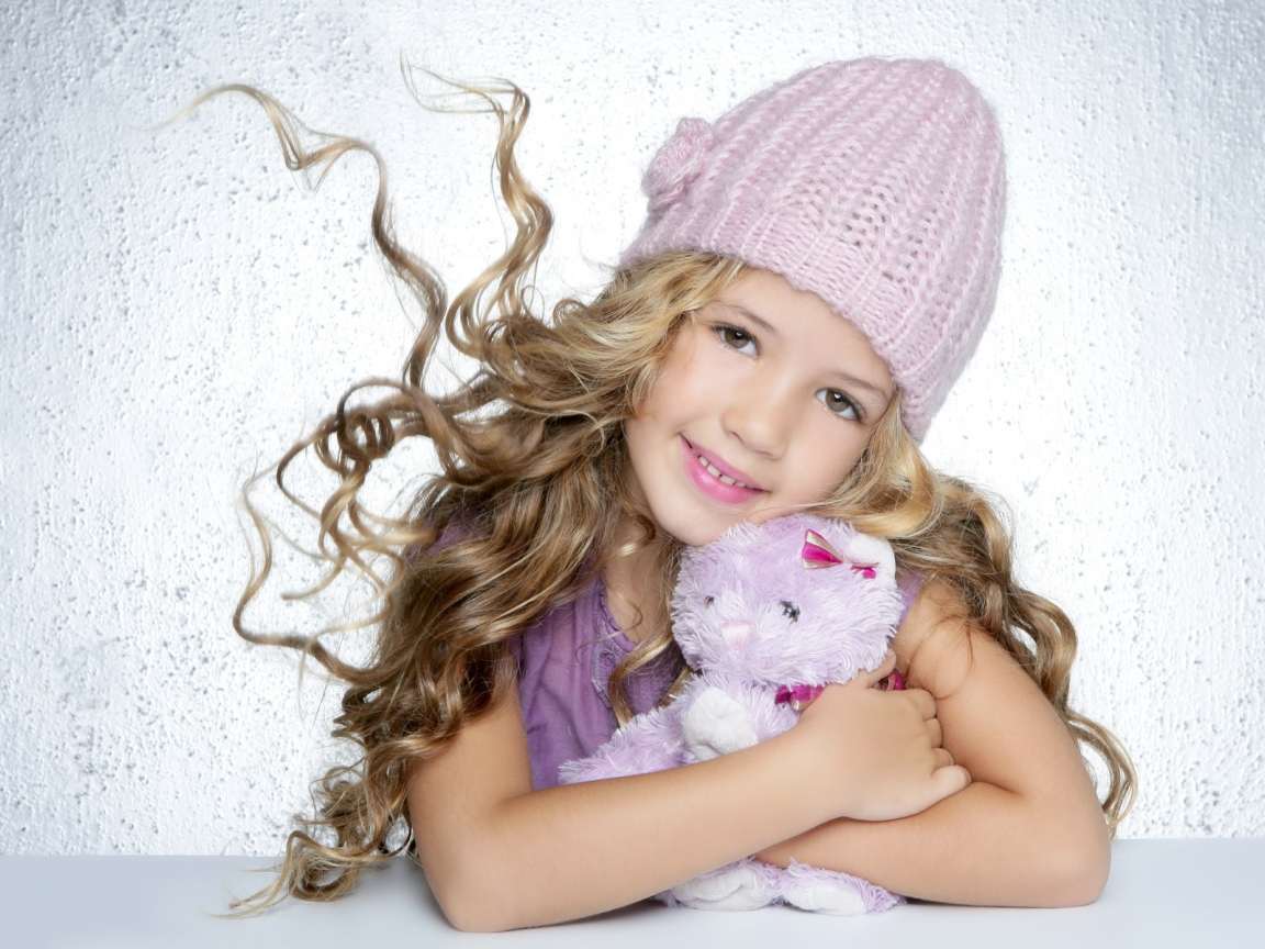 Милая светловолосая девочка с игрушкой