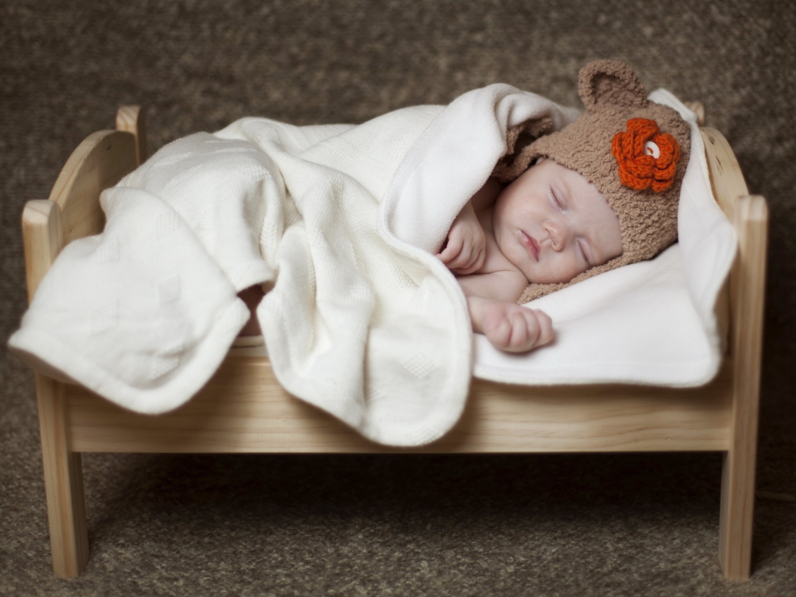 Грудной ребенок спит в маленькой кроватке
