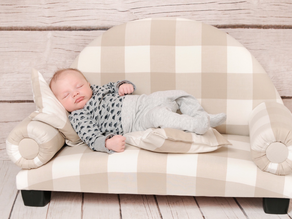 Грудной ребенок спит на диване