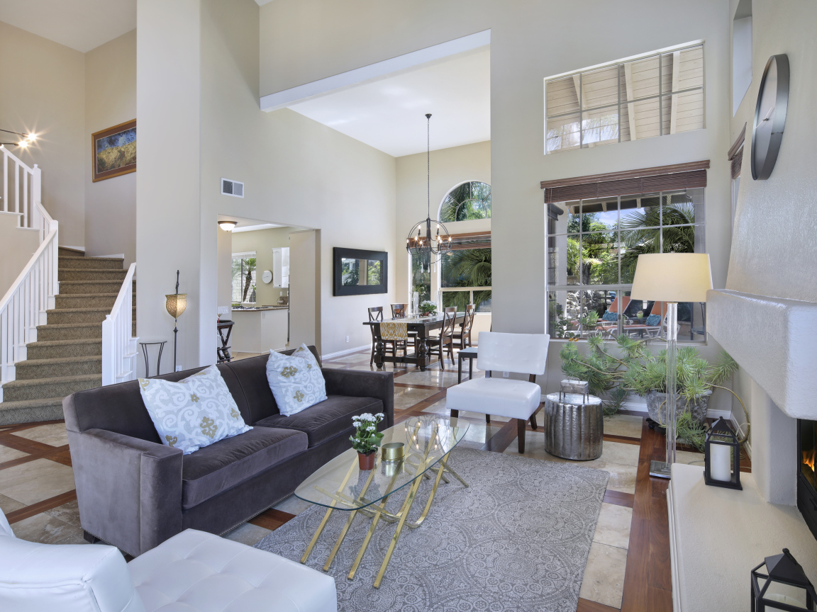 Светлая гостинная с камином и лестницей на второй этаж