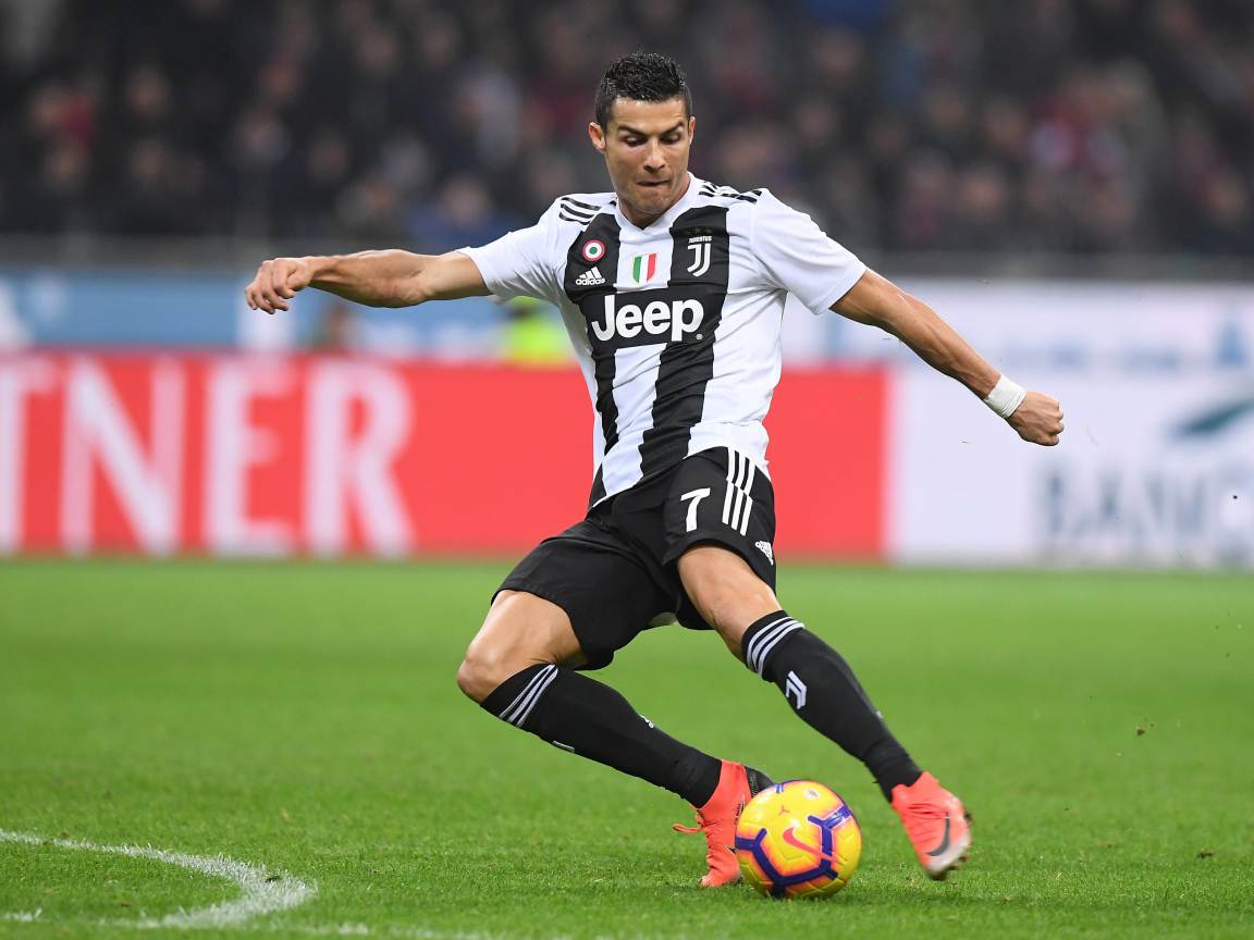 Футболист Криштиану Роналду отбирает мяч на футбольном поле 