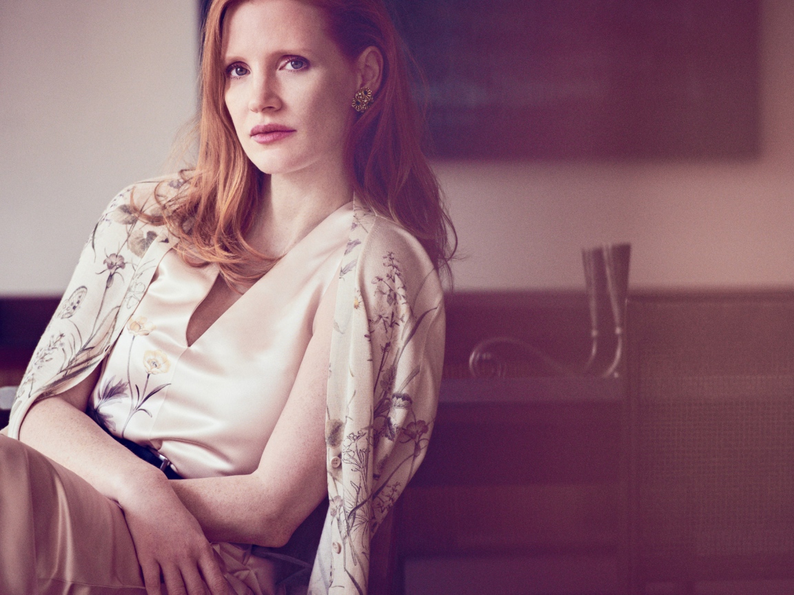 Молодая рыжеволосая актриса Джессика Честейн сидит на стуле