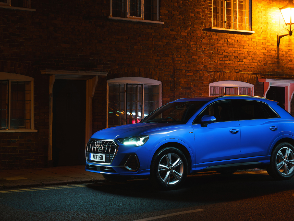 Blue Audi Q3 35 TFSI S Line car against the background of the building in the evening