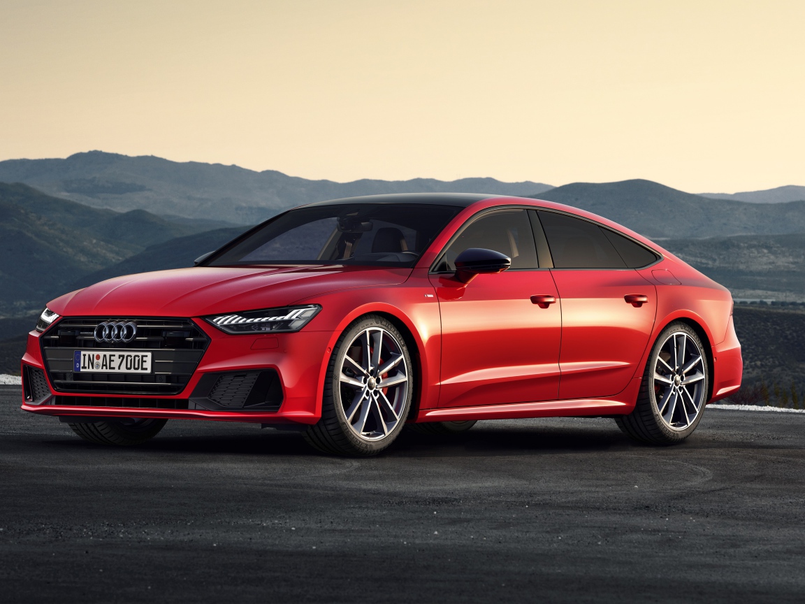 Красный автомобиль Audi A7 Sportback 55 TFSI E Quattro S Line 2019 года в горах