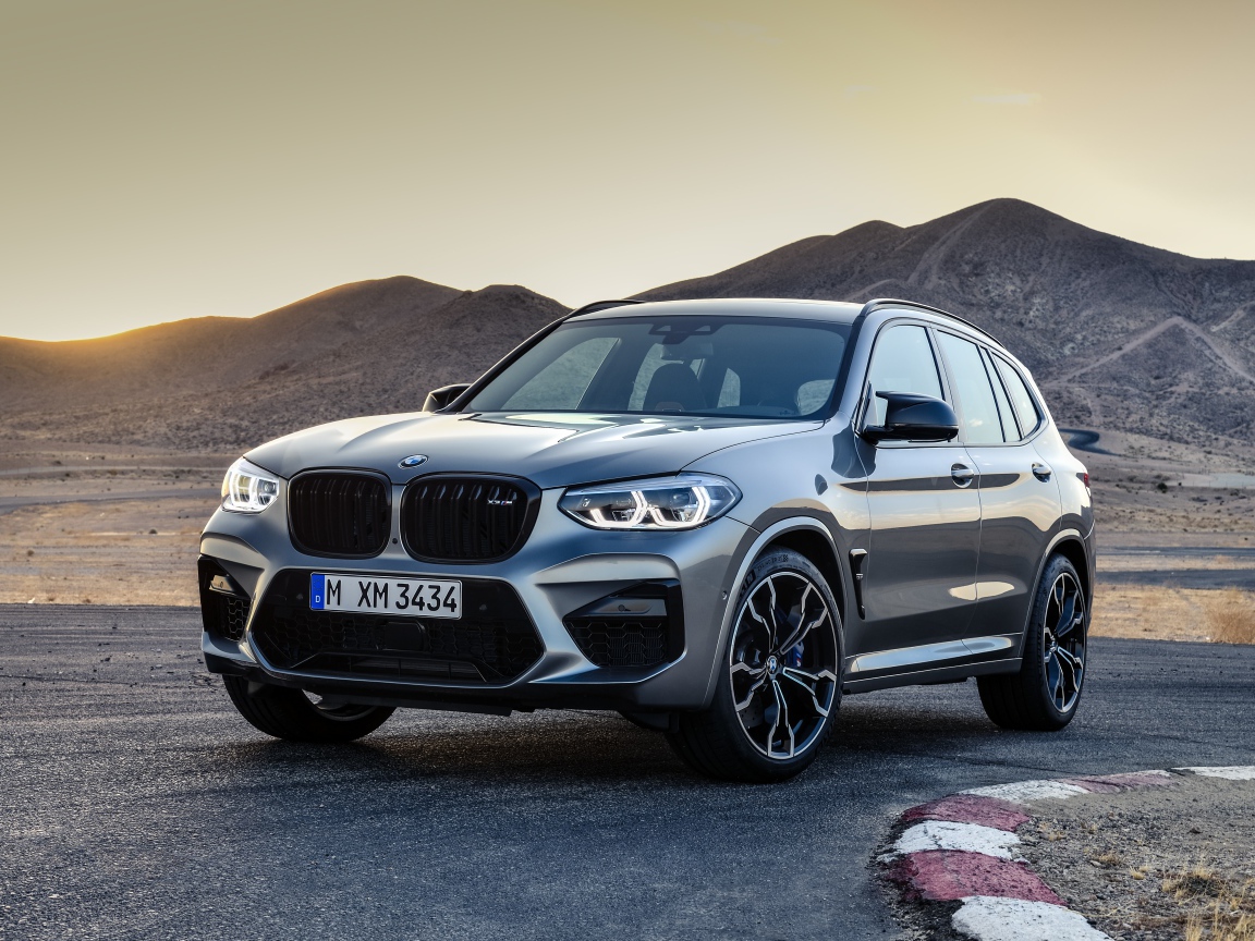Серебристый автомобиль BMW X3  на асфальте