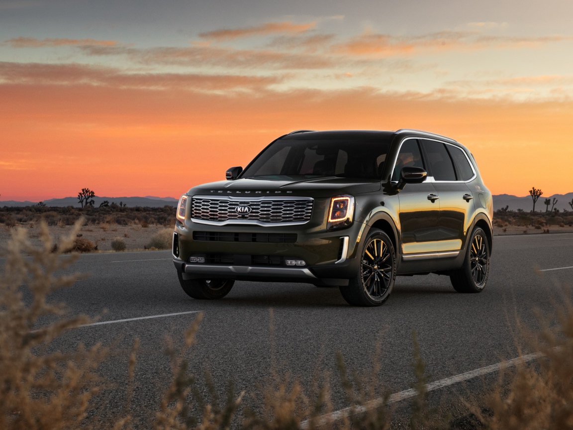 Черный внедорожник Kia Telluride, 2020 года на фоне заката 
