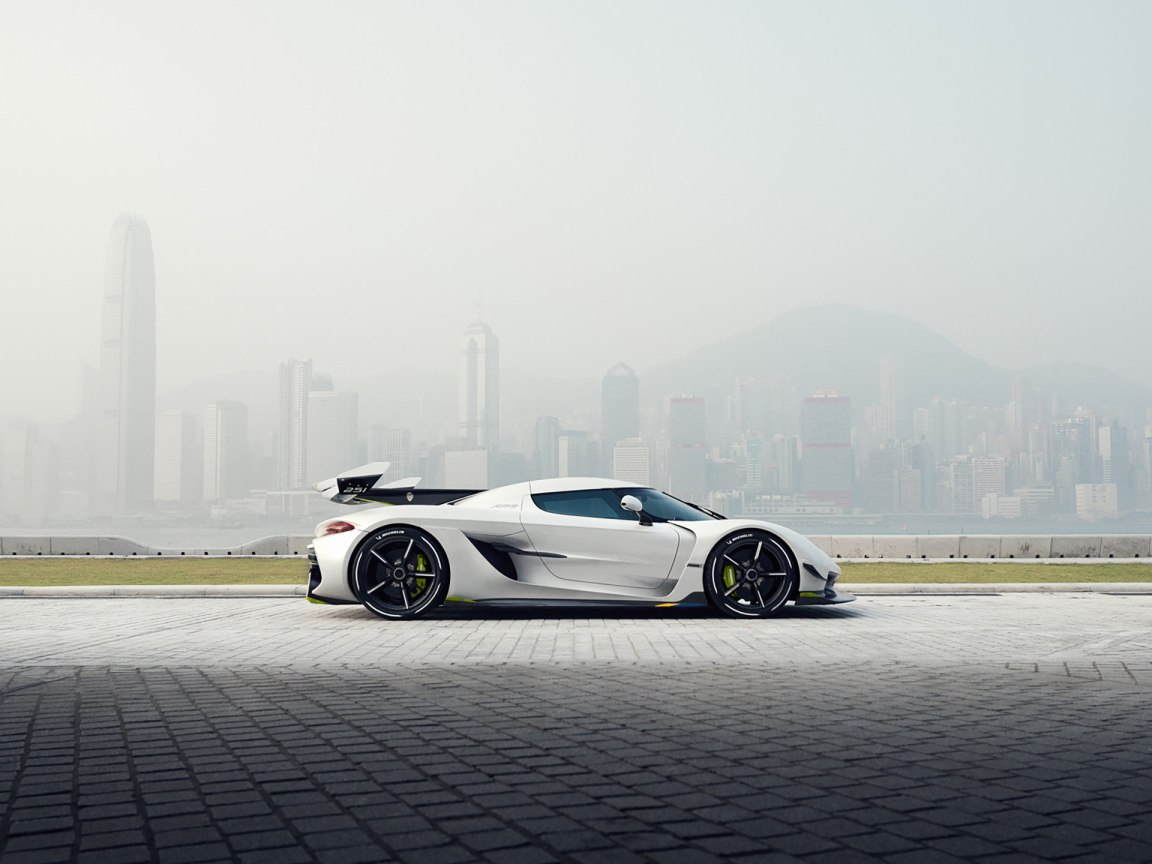 Белый автомобиль  Koenigsegg Jesko, 2019 года на фоне туманного города