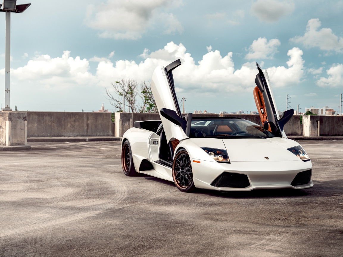 Белый автомобиль Lamborghini Murcielago с открытыми дверями