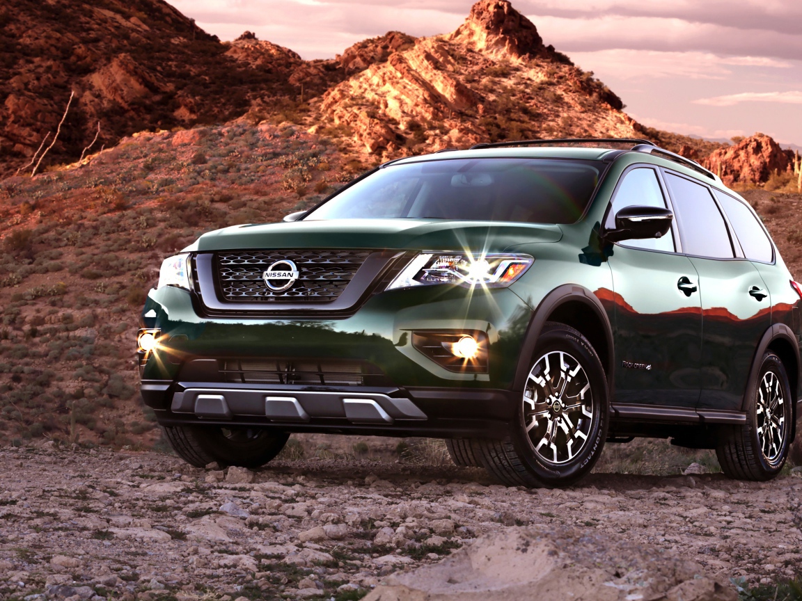 Зеленый автомобиль Nissan Pathfinder в горах 