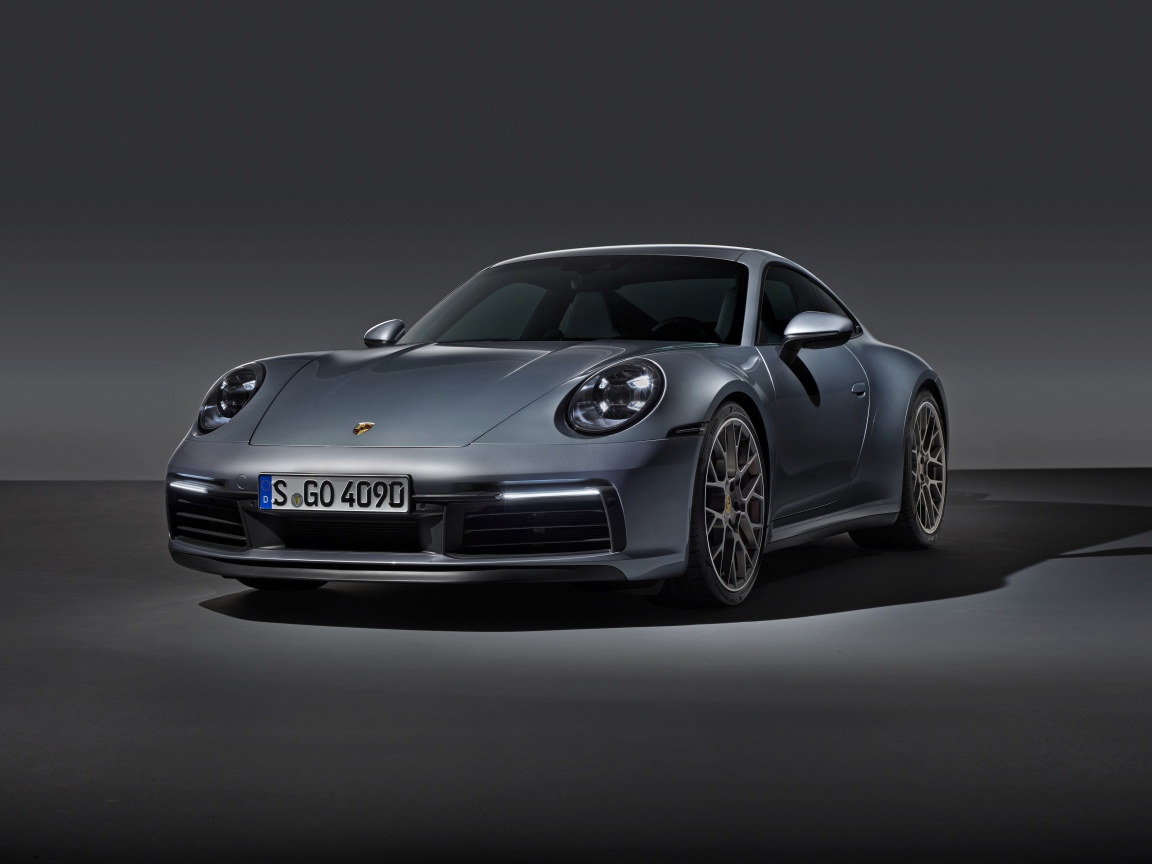 Серебристый автомобиль Porsche 911 Carrera 4S на сером фоне