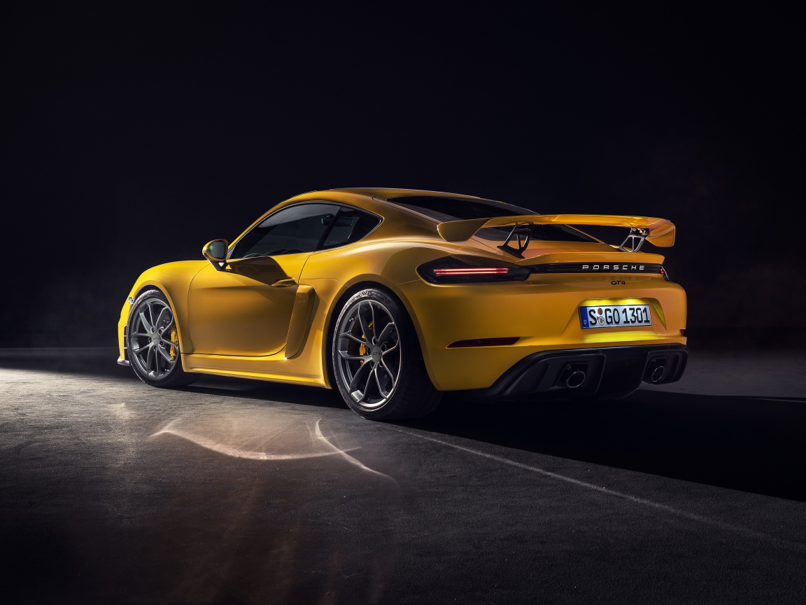 Желтый автомобиль Porsche 718 Cayman GT4, 2019 года вид сзади