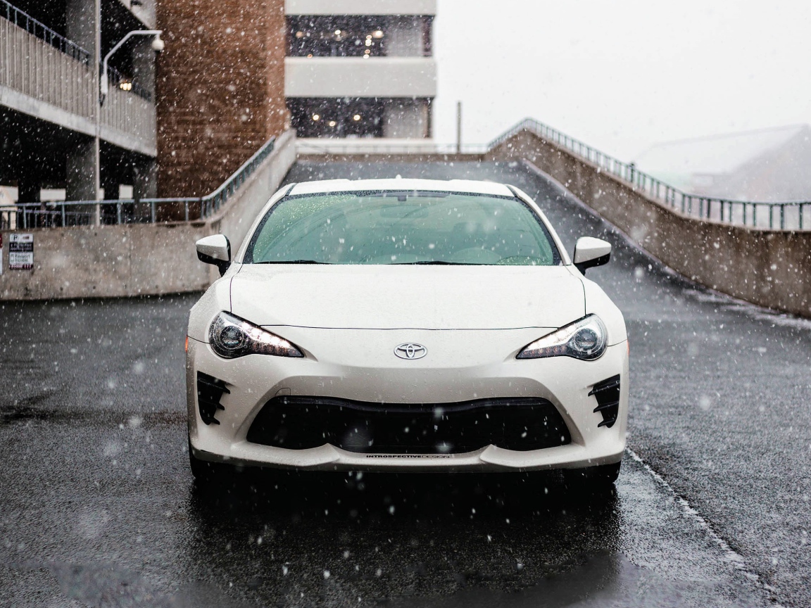 Белый автомобиль Toyota Supra на улице зимой