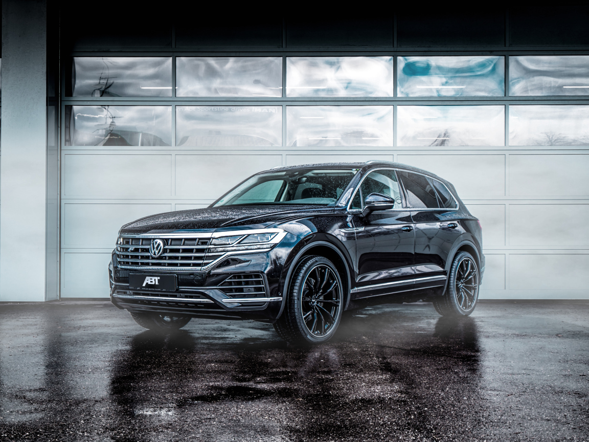 Черный автомобиль Volkswagen Touareg 2018 года у гаража