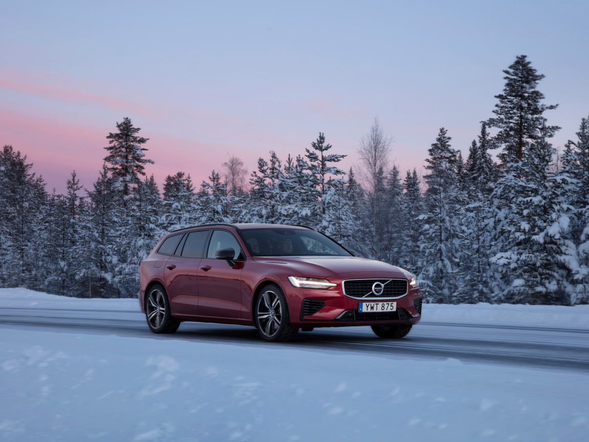 Красный автомобиль Volvo V60 на зимней дороге