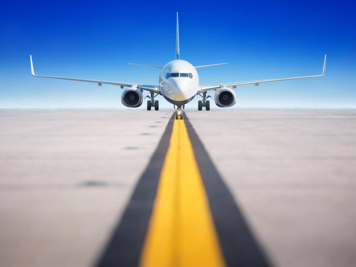 Большой пассажирский самолет на взлетной полосе на фоне голубого неба