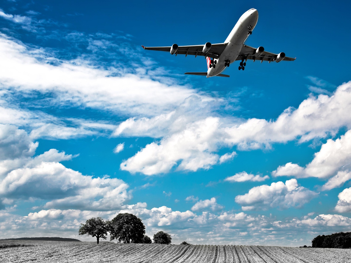 Самолет авиакомпании Swiss Airlines в небе с белыми облаками