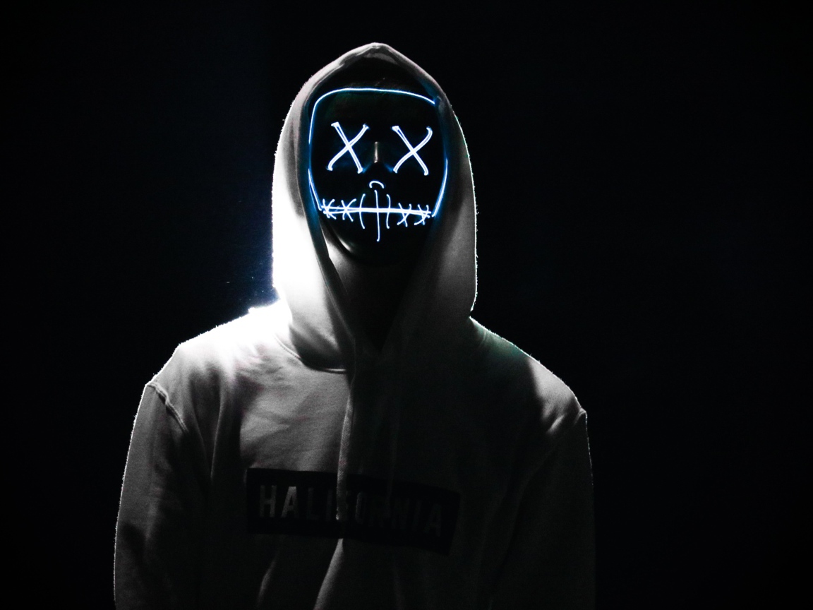 Светящаяся маска на лице у парня в худи