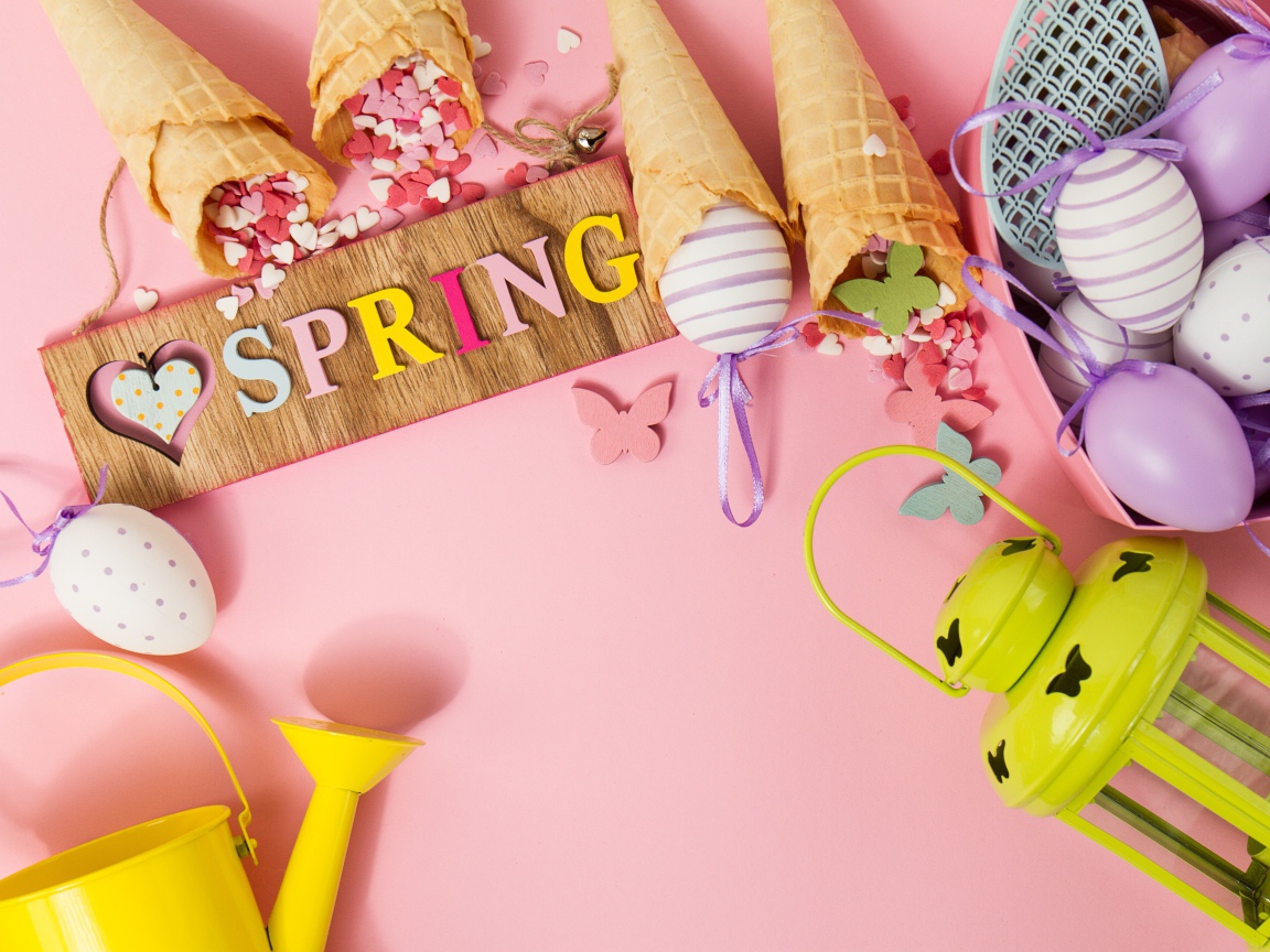 Надпись весна с вафельными рожками и яйцами на розовом фоне
