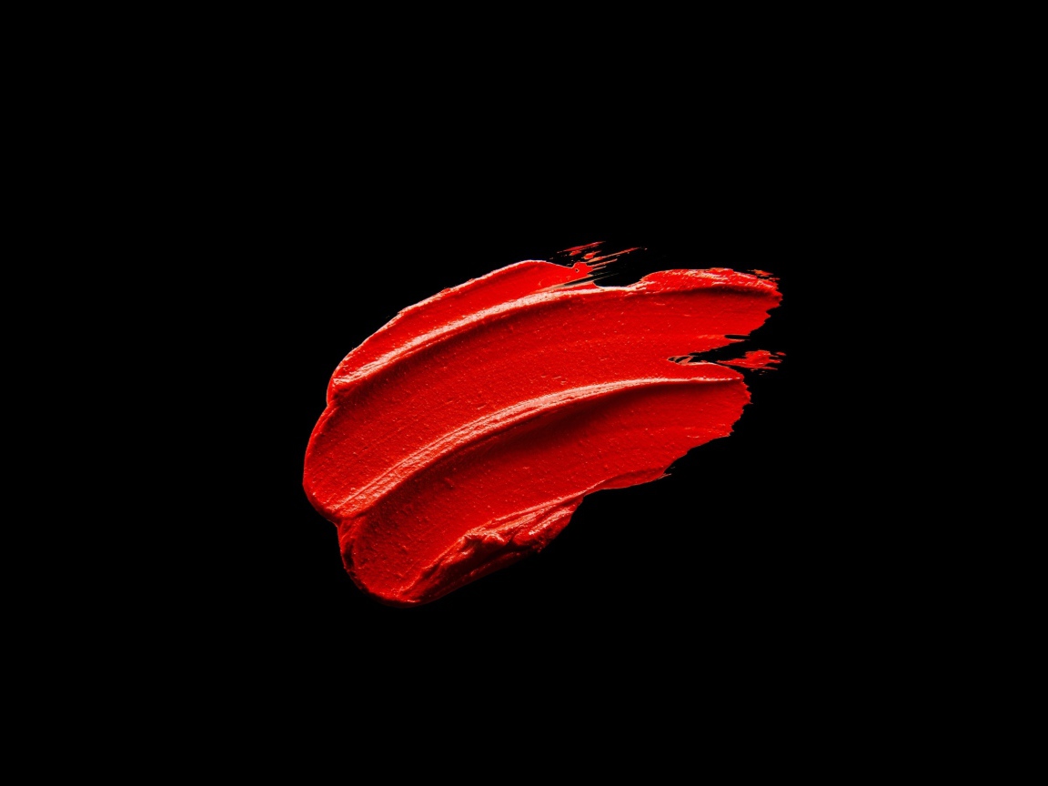 Мазок красной краски на черном фоне