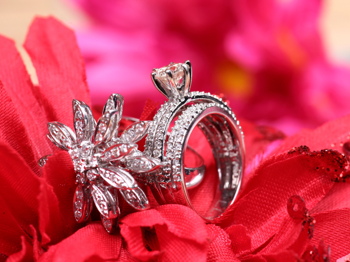 Два кольца с камнями лежат на цветке 