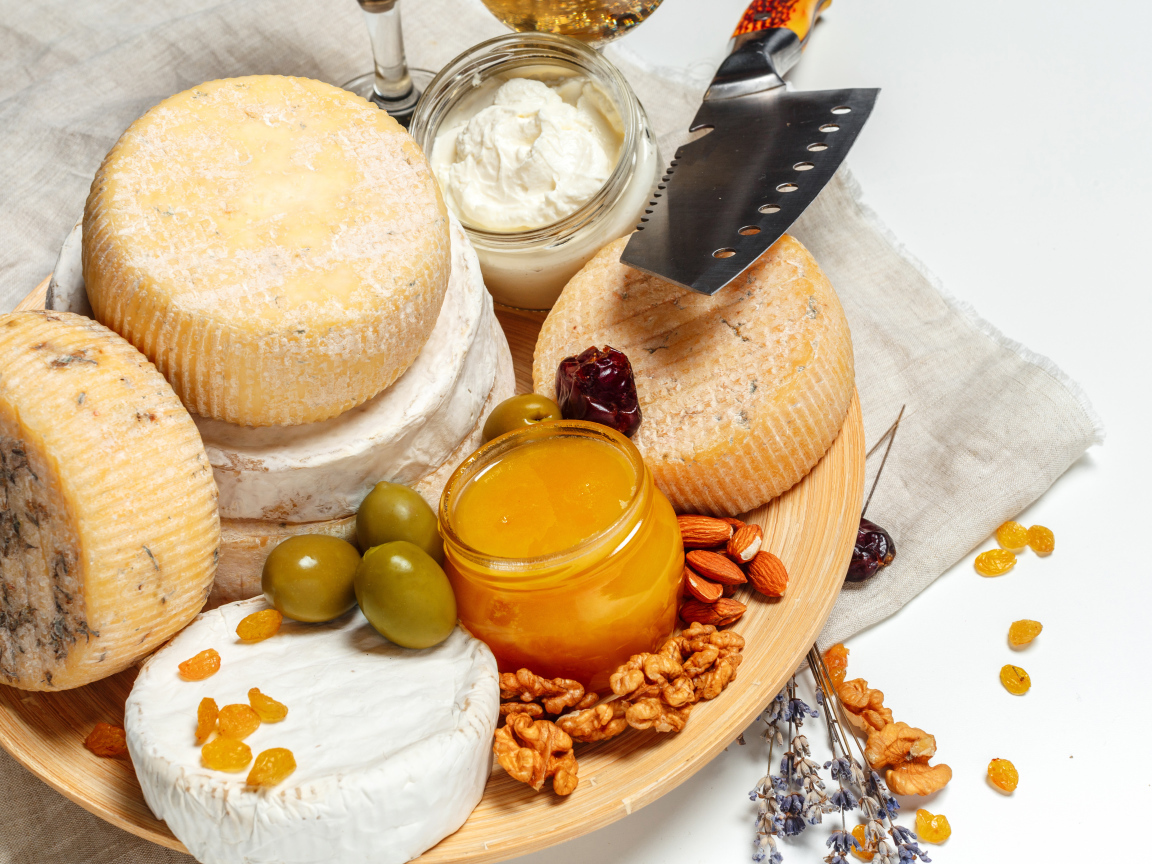 Сыр с плесенью на тарелке оливками, орехами и медом 