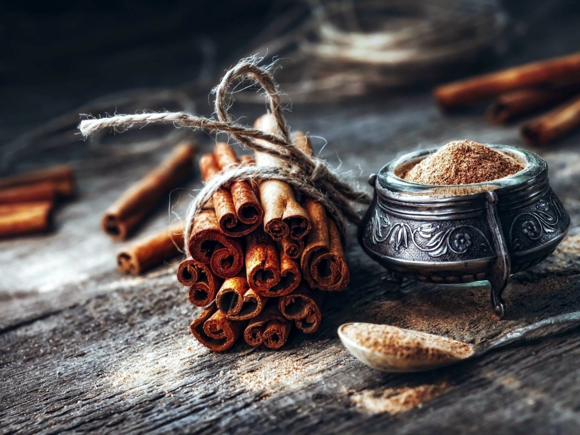 Палочки корицы на столе с молотой корицей