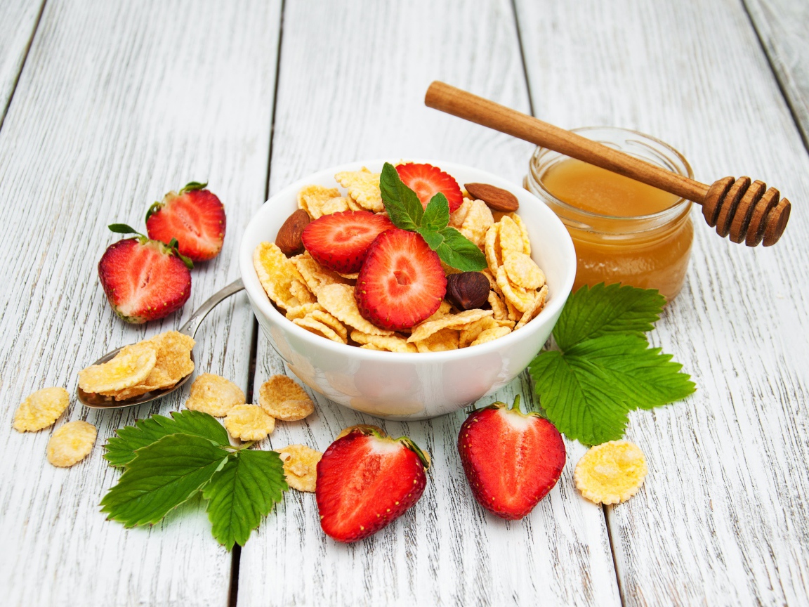 Кукурузные хлопья в миске с клубникой и медом