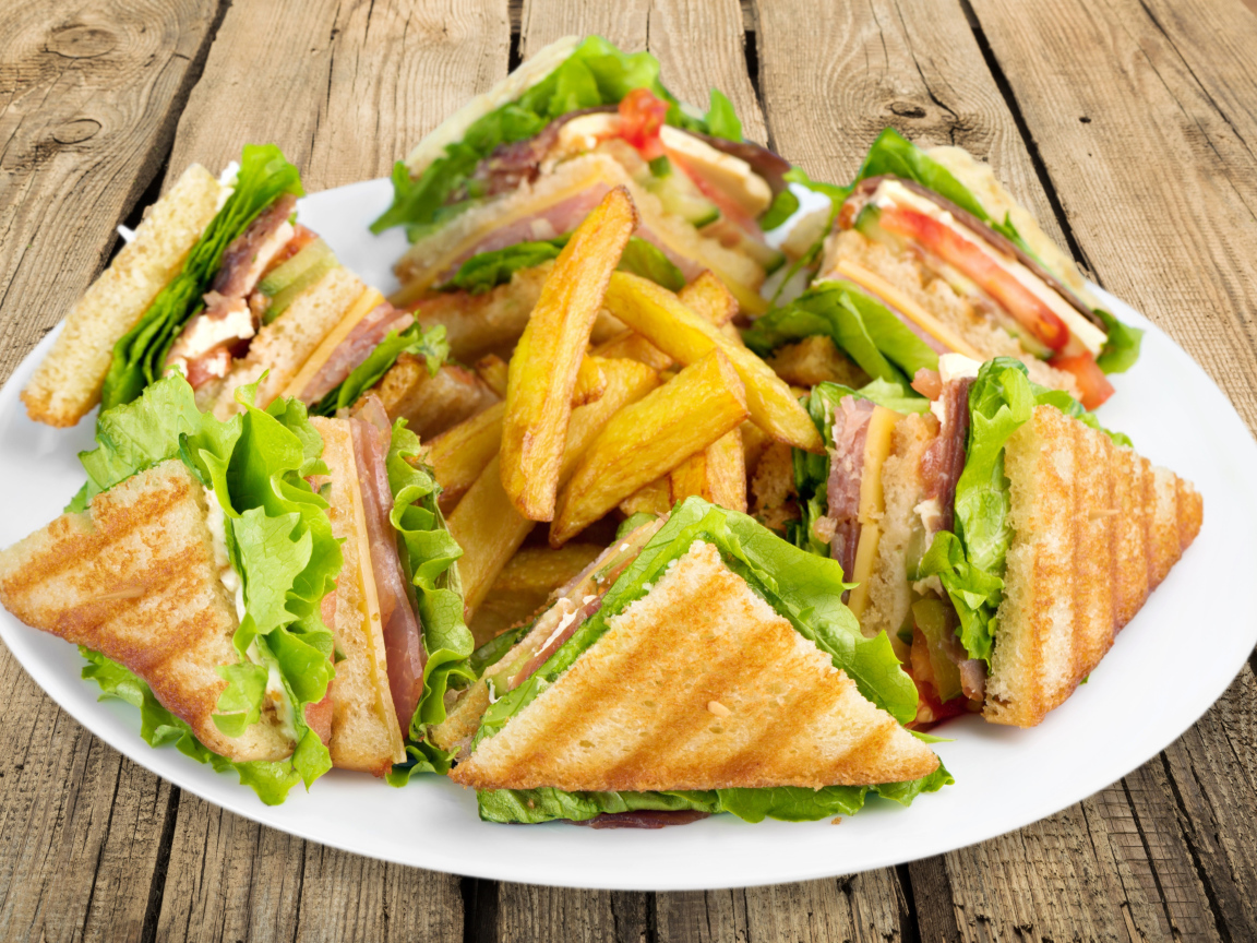 Сэндвичи с ветчиной на тарелке с картофелем фри 