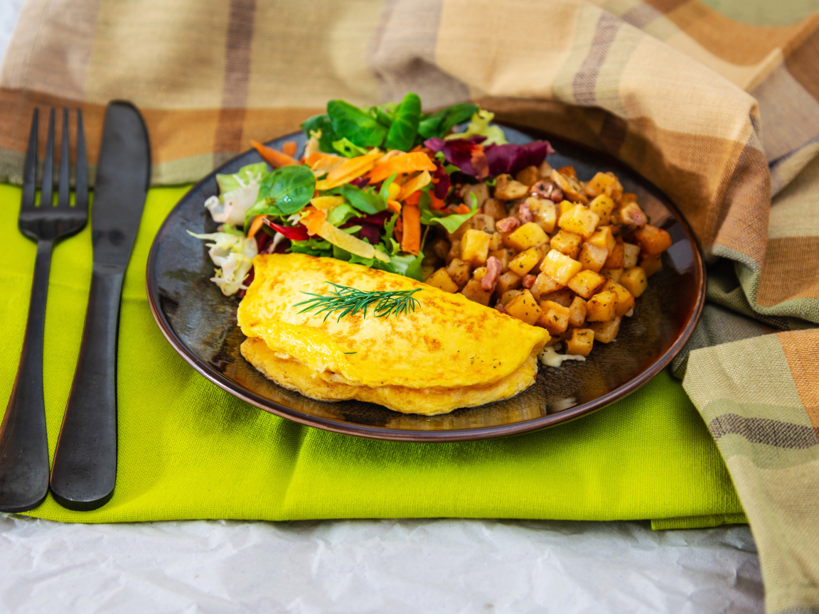Омлет на тарелке с салатом и овощами