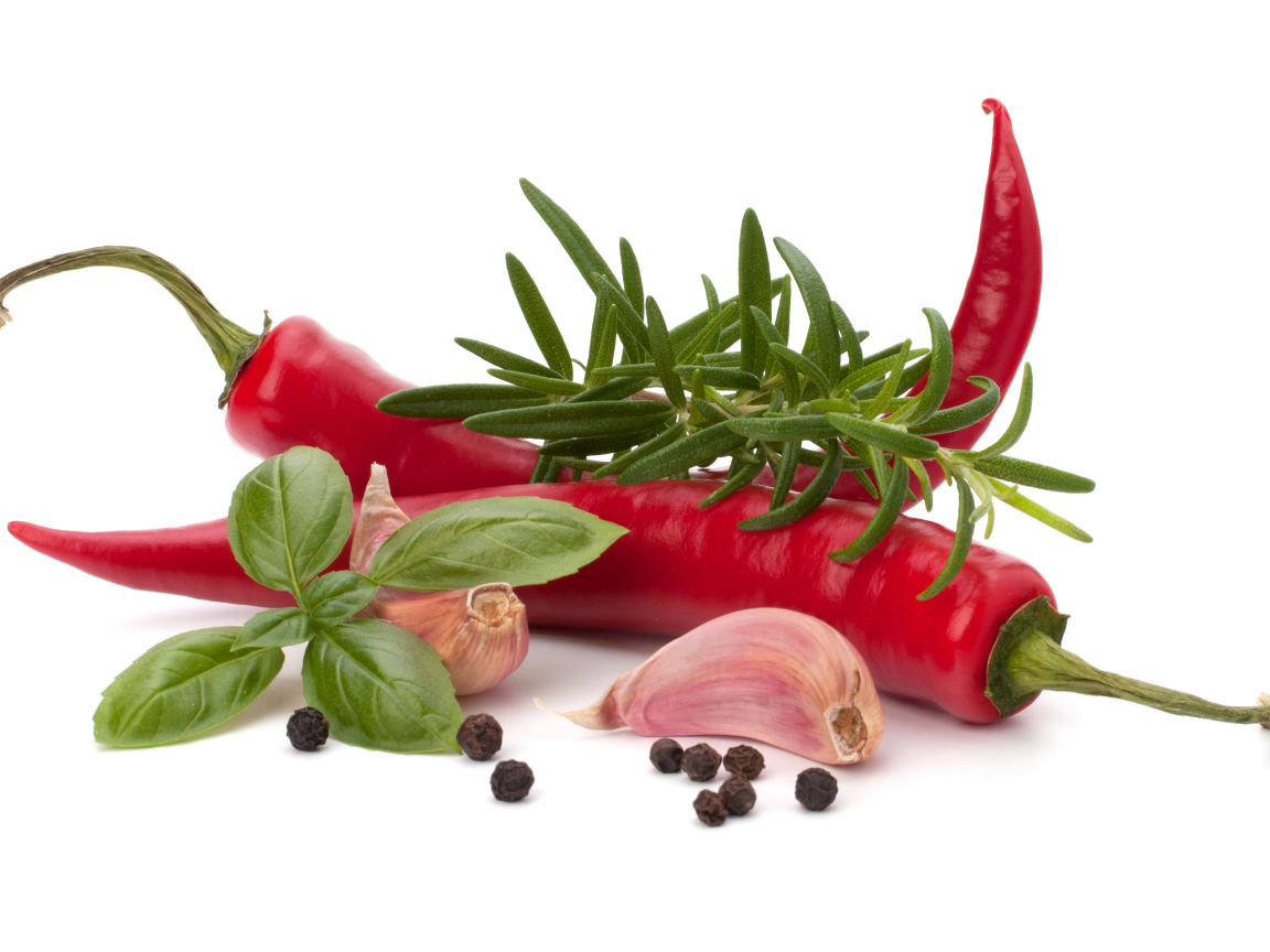 Красный перец с чесноком, базиликом, черным перцем и розмарином на белом фоне