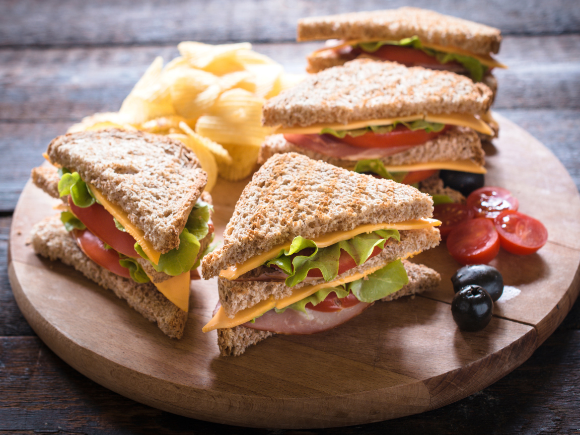 Сэндвичи на деревянной доске с оливками