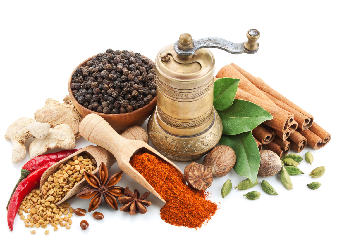 Пряные специи на столе с мельницей на белом фоне