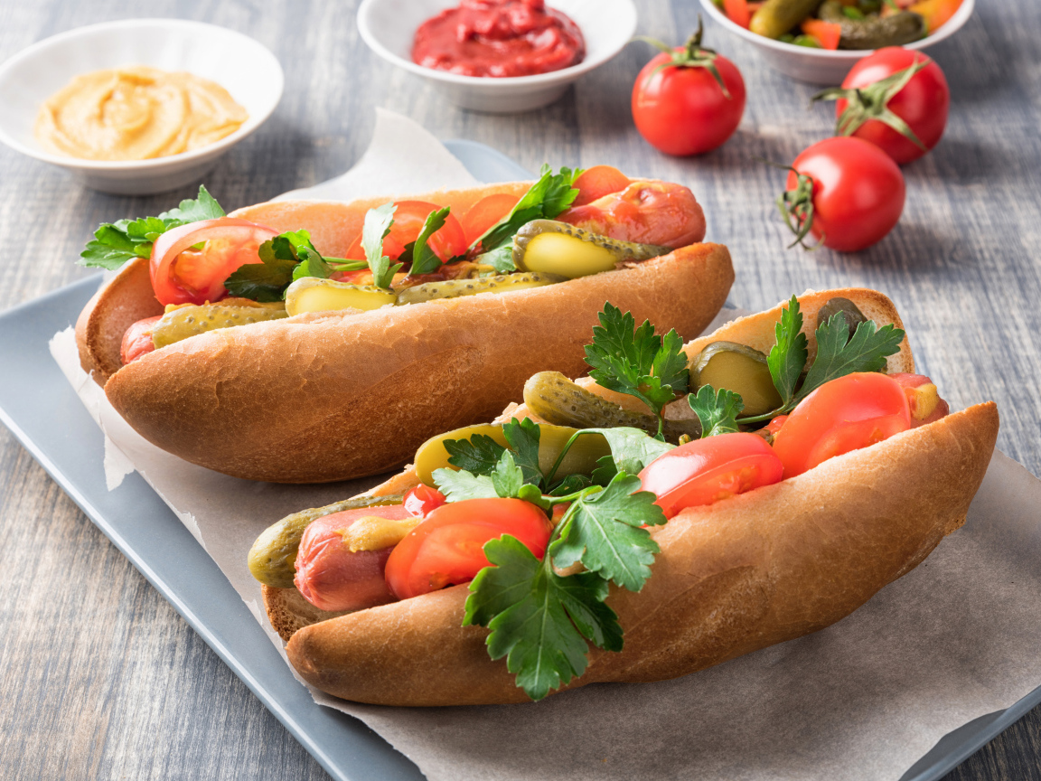 Два хотдога с сосиской, огурцами и помидорами