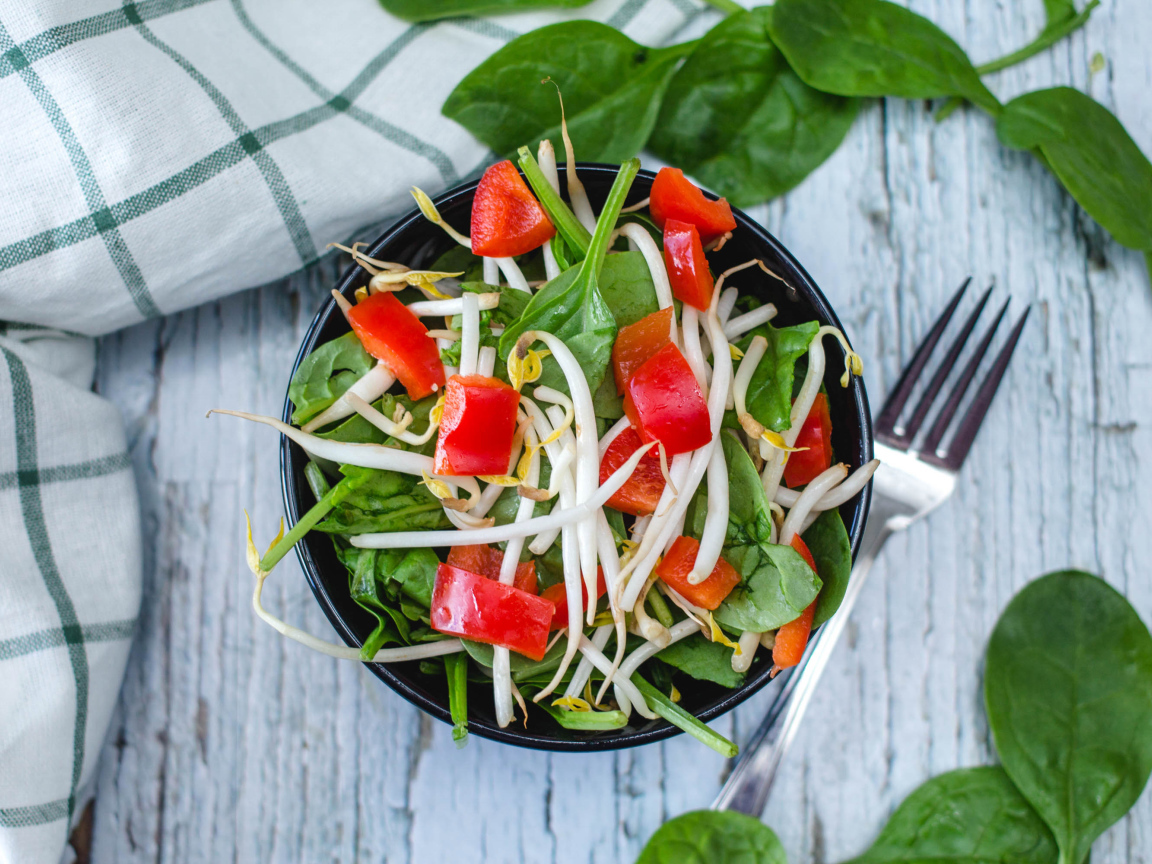 Овощной салат в миске на столе с вилкой