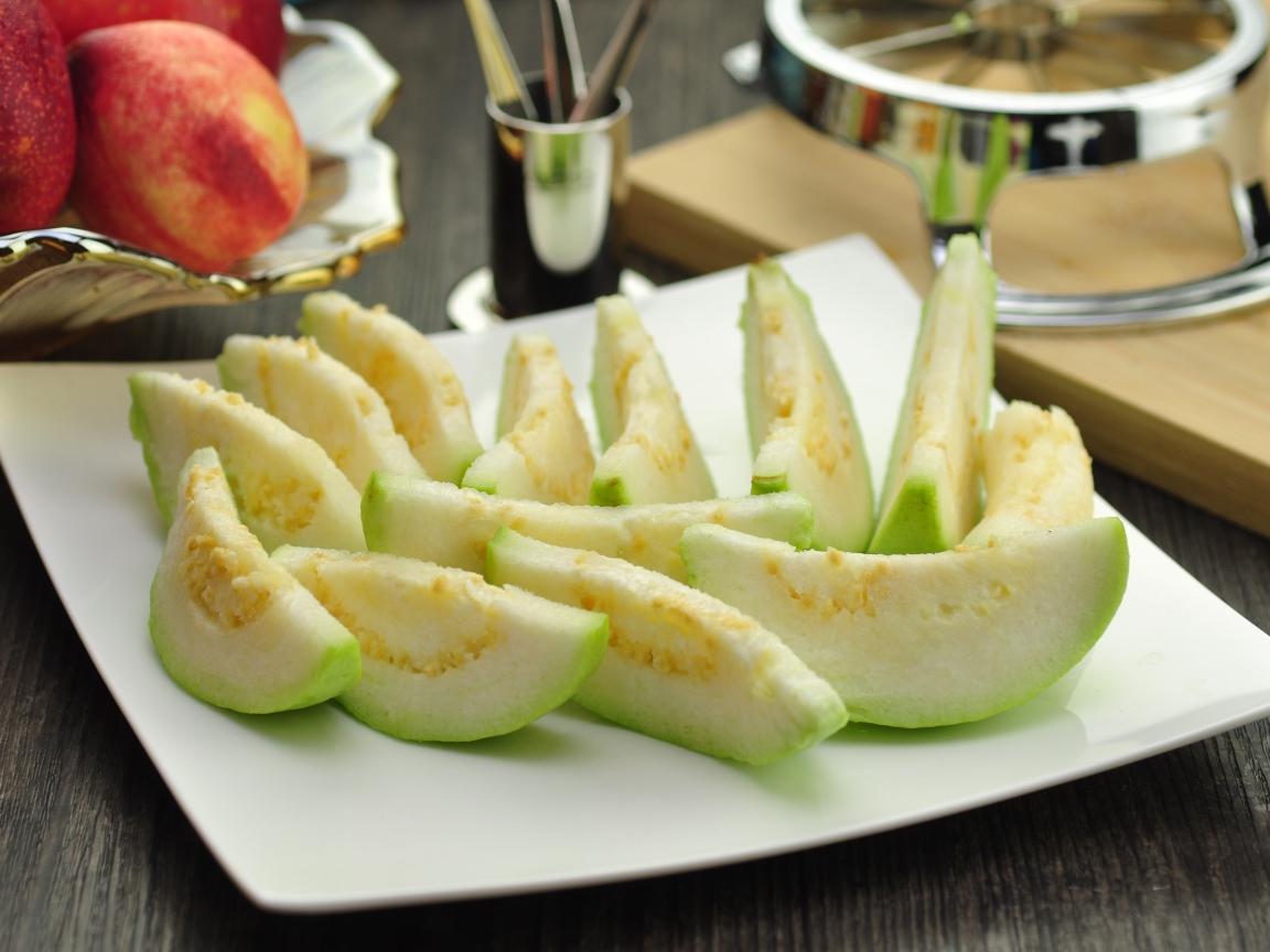 Кусочки плода гуава на белой тарелке