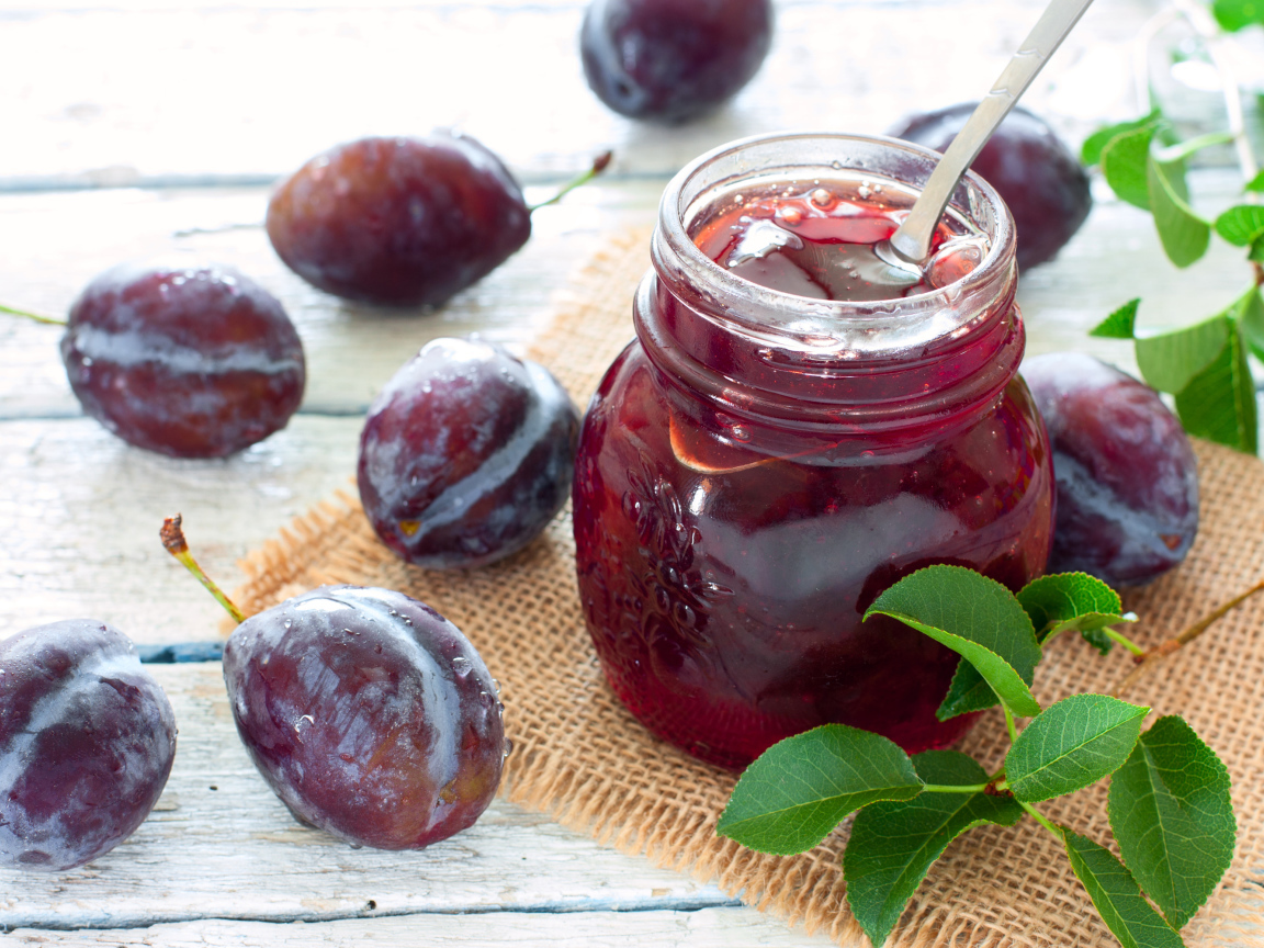 Джем в банке на столе со сливами