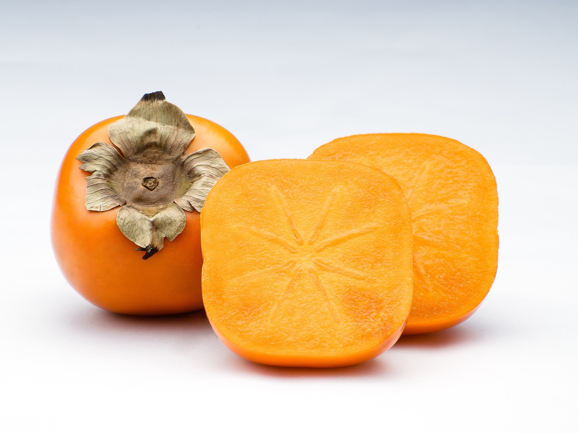 Оранжевая хурма на сером фоне крупным планом