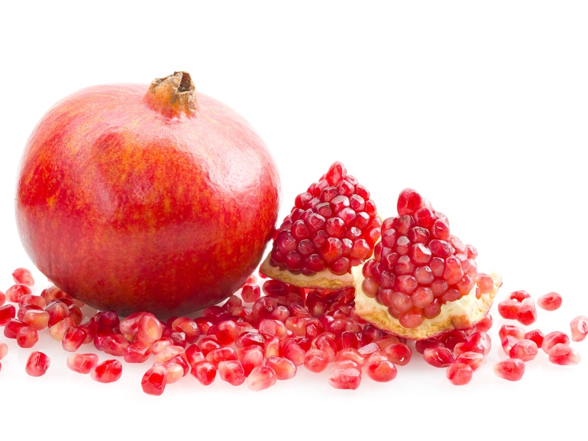 Красный гранат с зернами на белом фоне